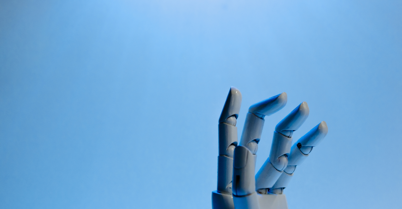 On a blue background a robot hand reaches up, to reflect AI for this AI glossary.