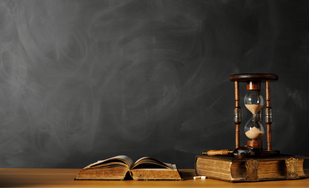 On a black background is a sand timer and some old books to reference the need organizations have for a content refresh.