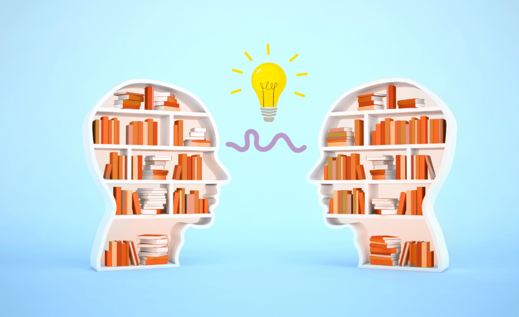 Two head shaped bookcases with books in them facing eachother, with a squiggly line and a light bulb between them symbolising knowledge transfer.