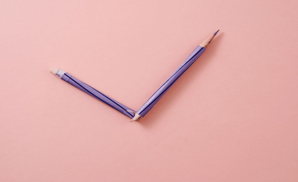 A broken pencil on a pink background symbolizing content errors.